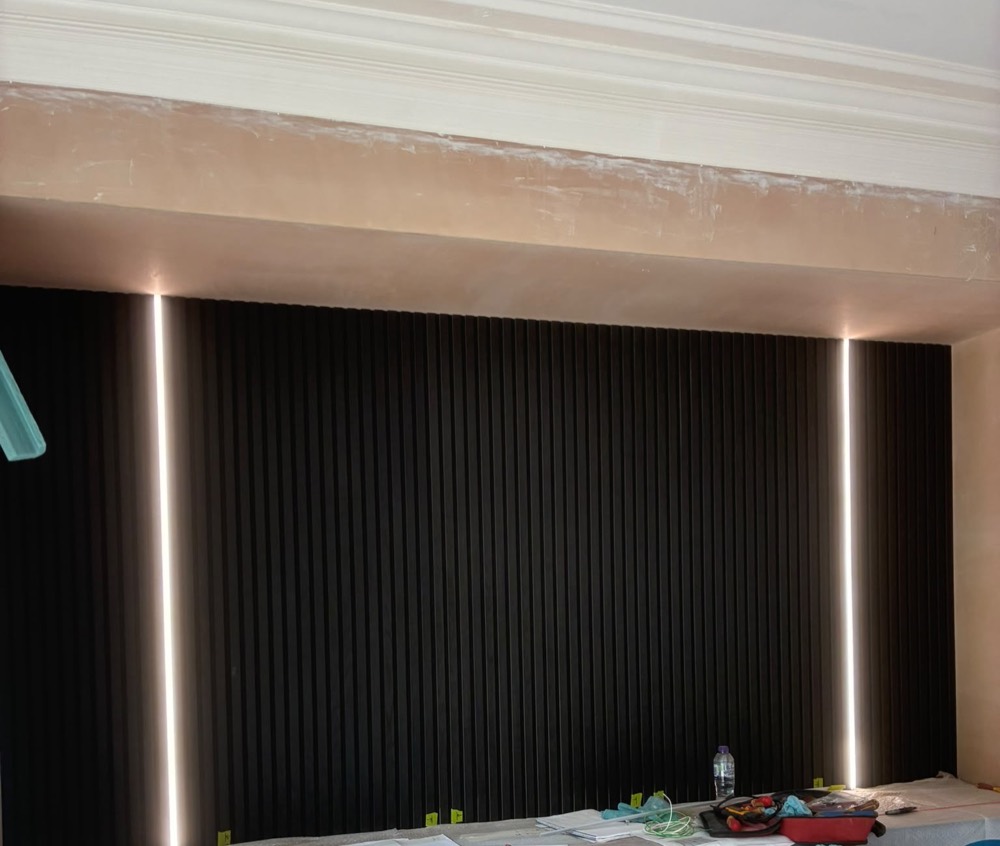 Media wall with recessed vertical LED strip lighting installed by Lux-smart electrics